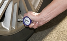 photo of man checking tire pressure