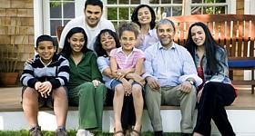 Large family sitting on a porch posing for their picture.